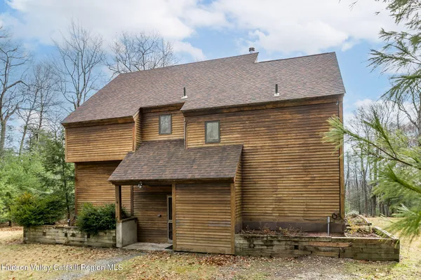 a front view of a house with a tree