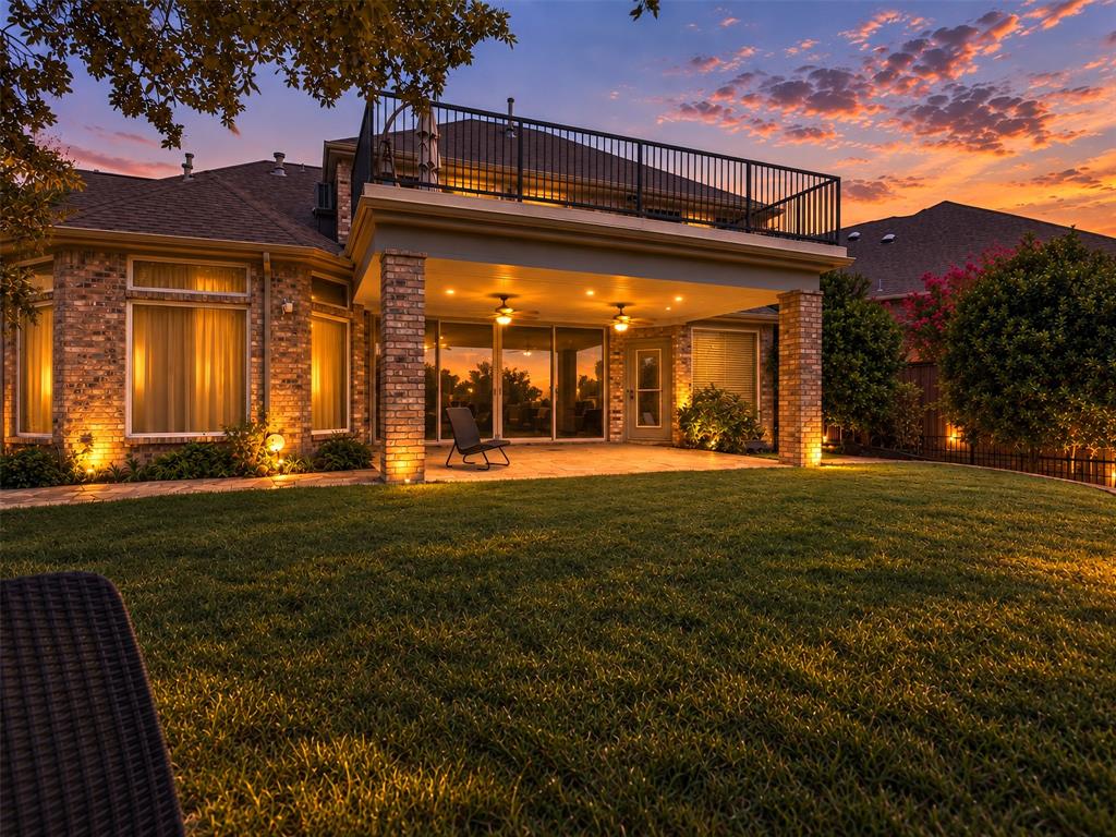 6809 Cedar Ridge Court Plano, TX 75093 - Photo 36 of 38 Brick exterior with a covered patio, second-story balcony with metal railing, and a manicured lawn