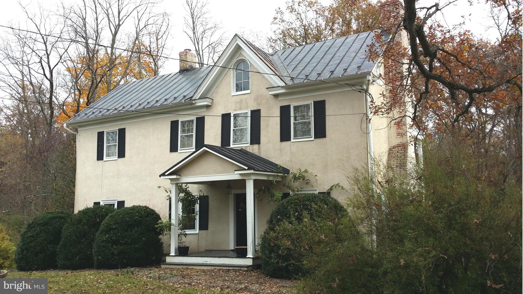 a front view of a house with yard and trees around