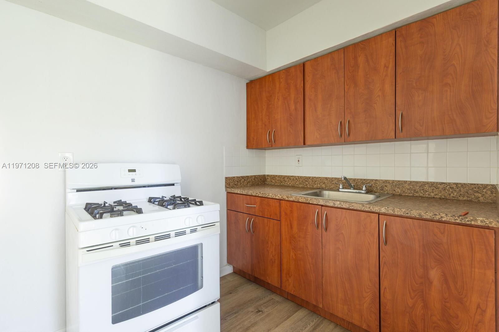 26701 Southwest 137th Avenue, Unit 4 Homestead, FL 33032 - Photo 5 of 7 a kitchen with granite countertop cabinets washer and dryer