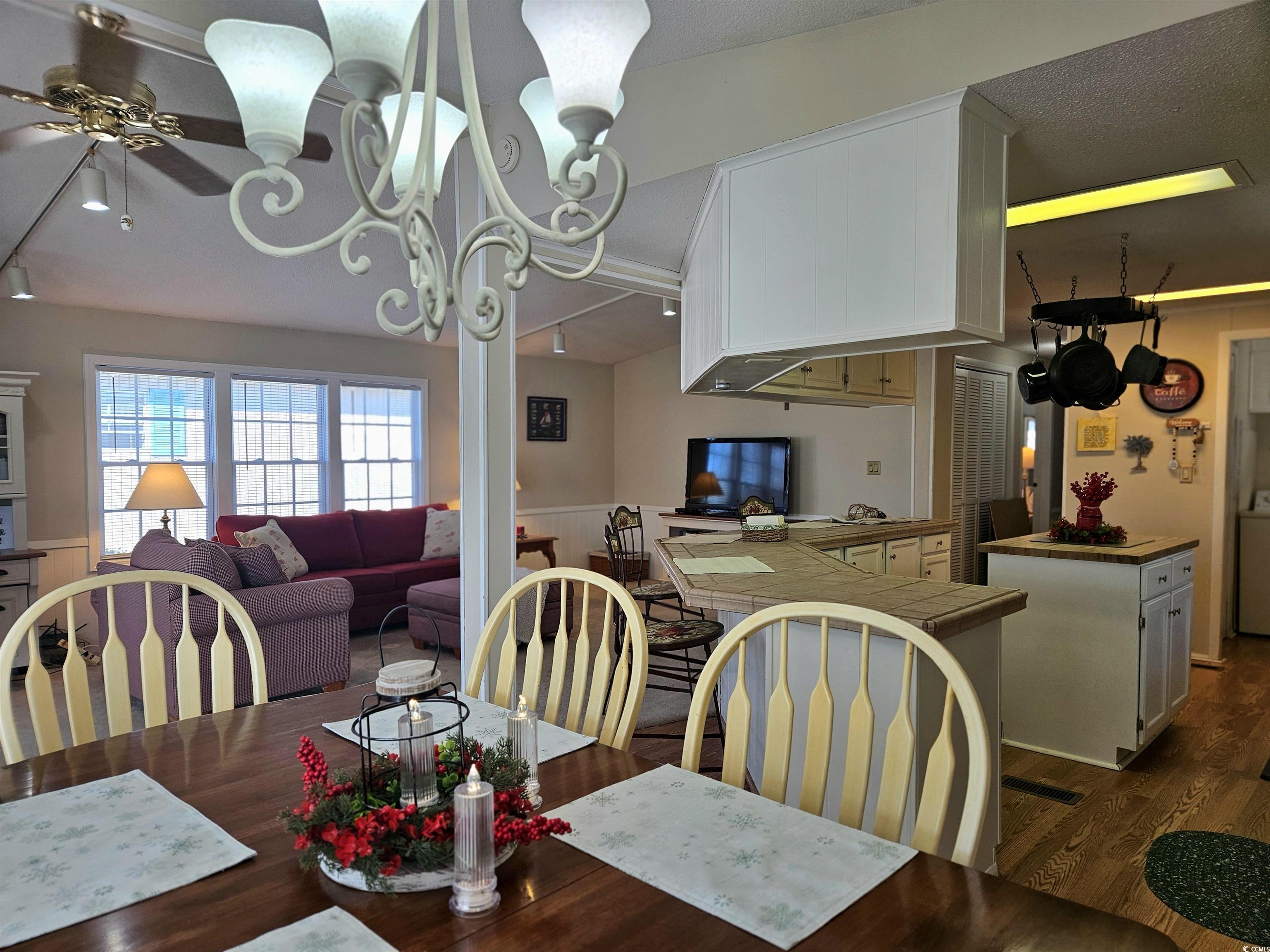471 Meadowlark Surfside Beach, SC 29575 - Photo 5 of 40 Dining area with a wainscoted wall, track lighting, dark wood-style floors, a chandelier, and washer / dryer