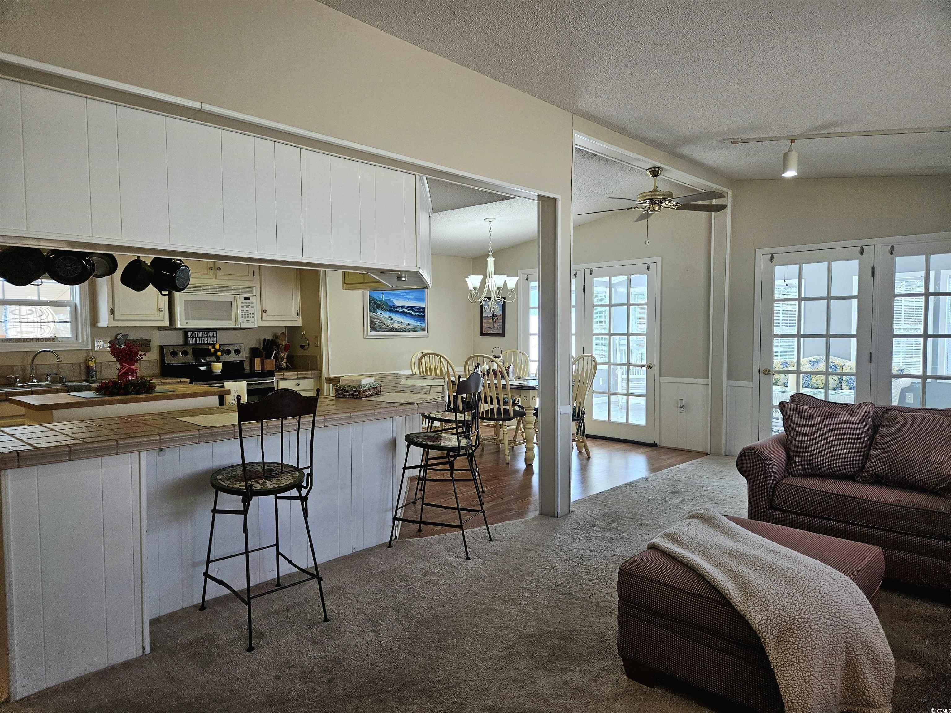 471 Meadowlark Surfside Beach, SC 29575 - Photo 8 of 40 Kitchen with tile counters, ceiling fan, vaulted ceiling, a kitchen bar, and electric range