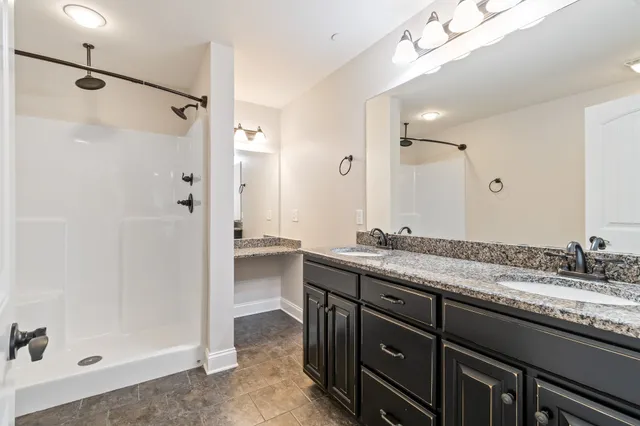 a bathroom with a granite countertop sink a mirror a shower and a bathtub