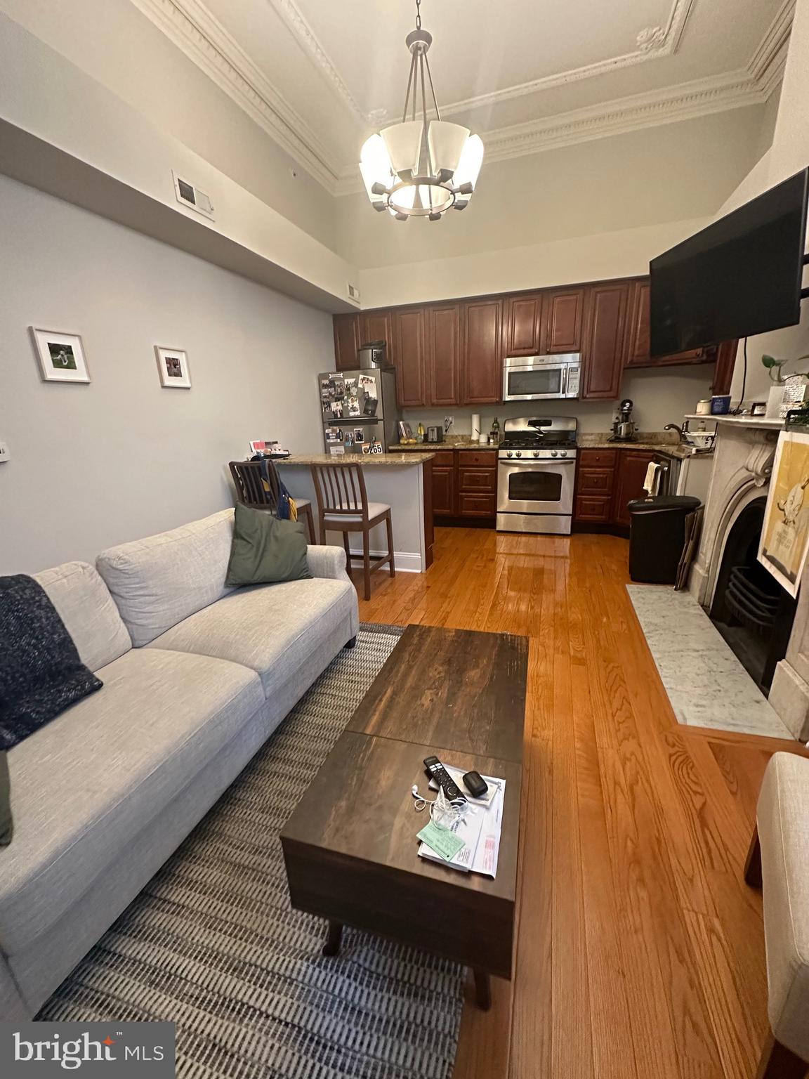 1014 Clinton Street, Unit 1R Philadelphia, PA 19107 - Photo 2 of 14 a living room with furniture kitchen view and a chandelier