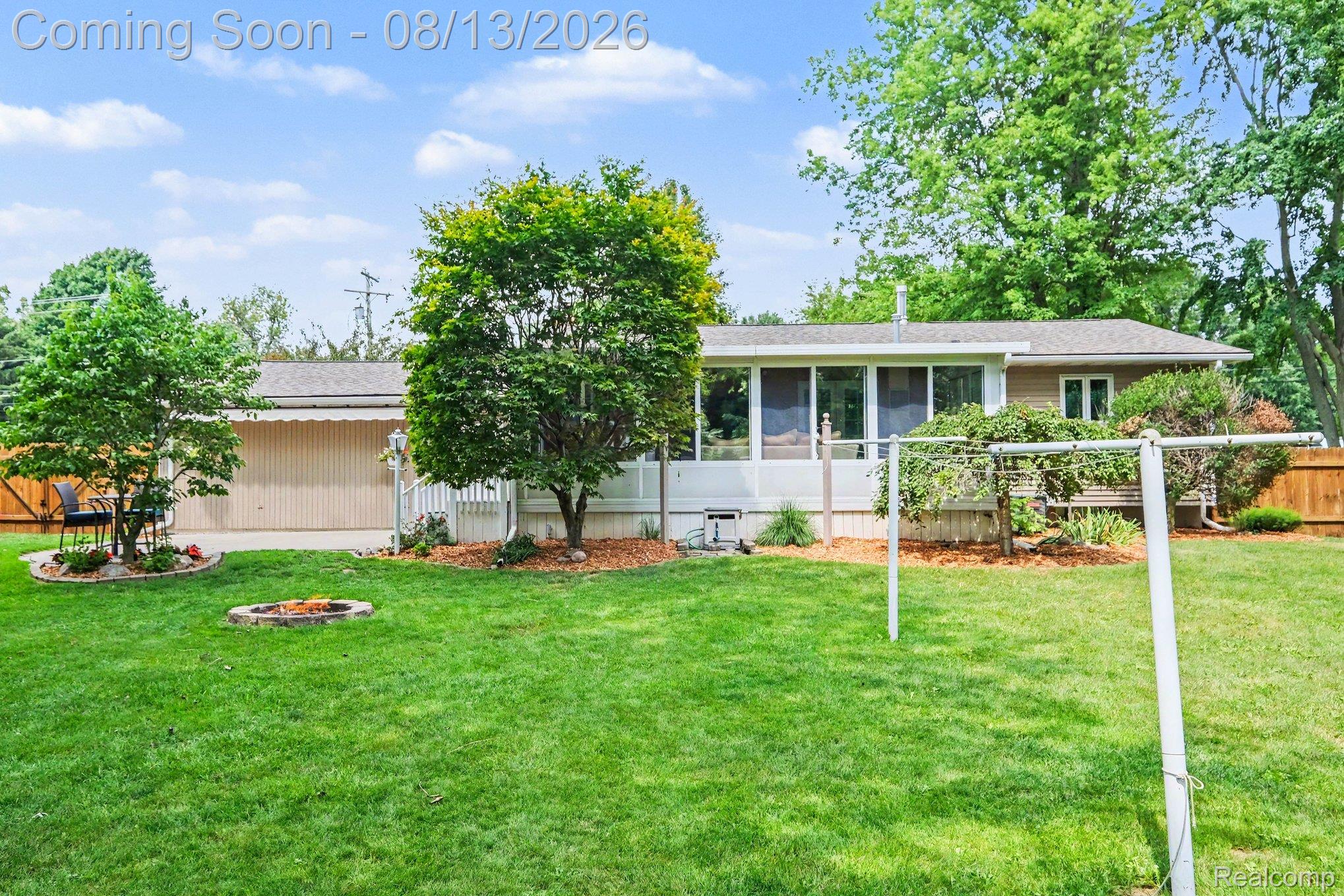 10361 Coldwater Road Flushing, MI 48433 - Photo 27 of 37 Expansive green lawn with mature trees and a fire pit