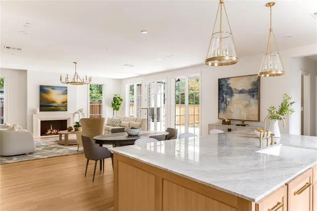a view of a dining room and livingroom with furniture wooden floor a chandelier