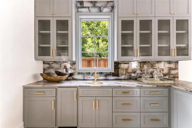 a kitchen with stainless steel appliances granite countertop white cabinets and a window