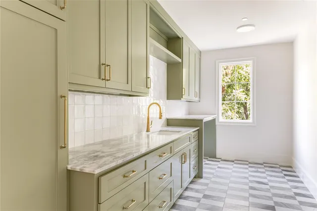 a kitchen with granite countertop a sink and a white wooden cabinets