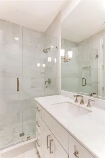 a bathroom with a shower sink and mirror