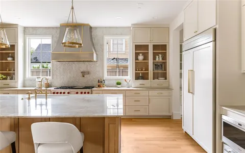 a kitchen with stainless steel appliances granite countertop a stove a sink and a refrigerator