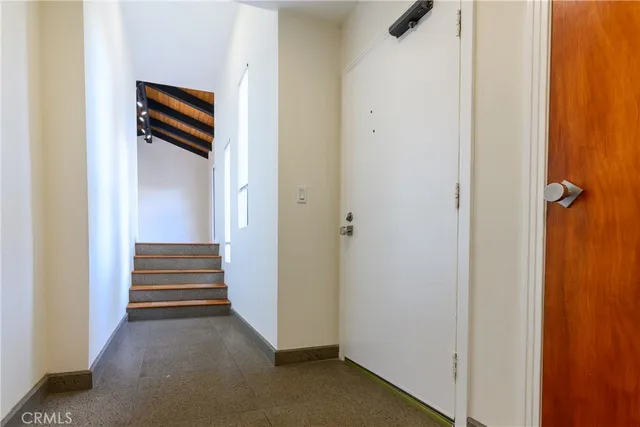 a view of a hallway with stairs and closet
