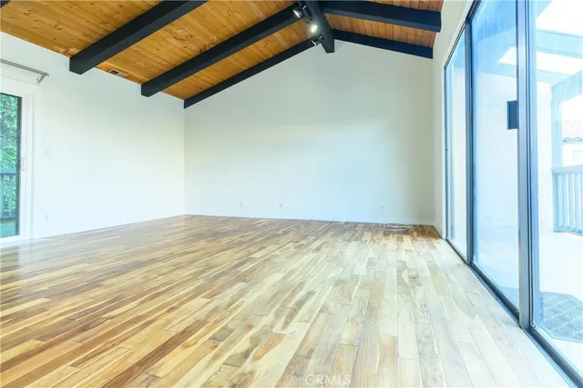 a view of a room with wooden floor and a ceiling fan