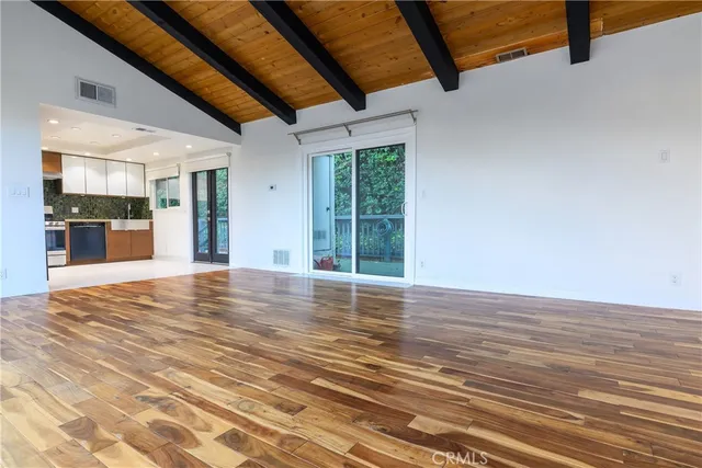 a view of a livingroom with wooden floor and large window