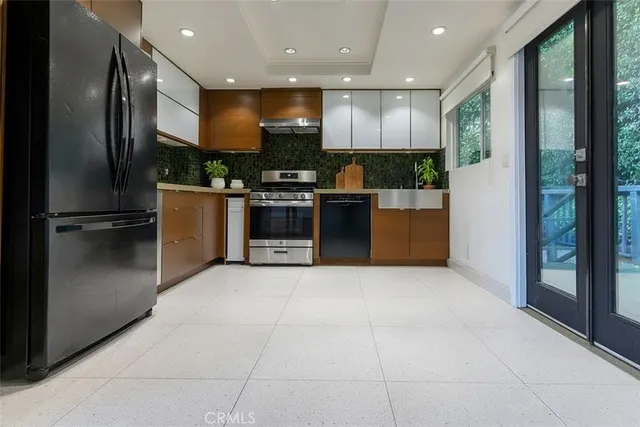 a kitchen with stainless steel appliances granite countertop a refrigerator and a stove top oven