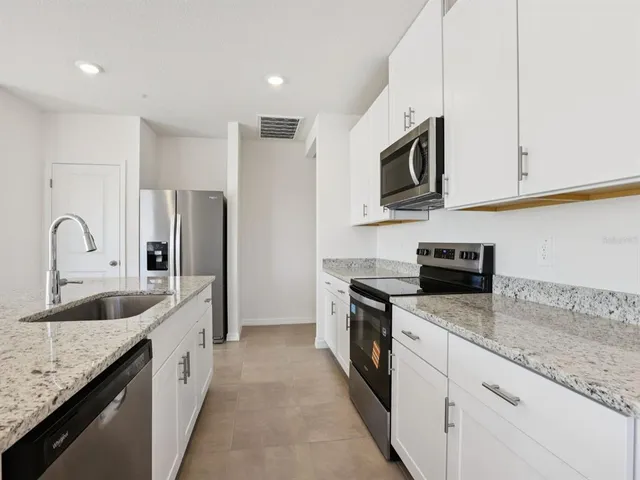 a kitchen with a sink vanity and refrigerator