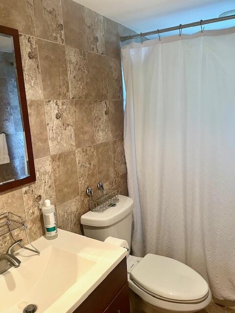 729 Normandy P Delray Beach Delray Beach, FL 33484 - Photo 5 of 6 a bathroom with a sink a toilet and shower curtain