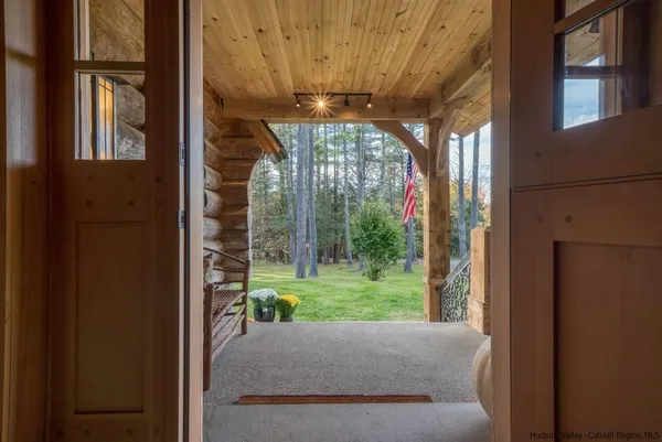 a living room with a floor to ceiling window and an outdoor view