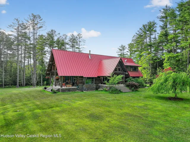 a view of a house with a yard and sitting area