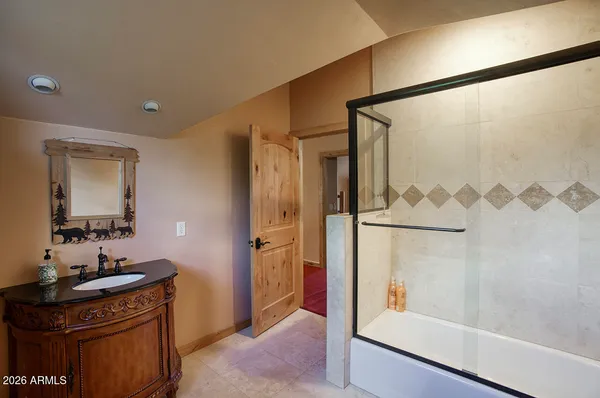 a bathroom with a granite countertop shower sink and mirror