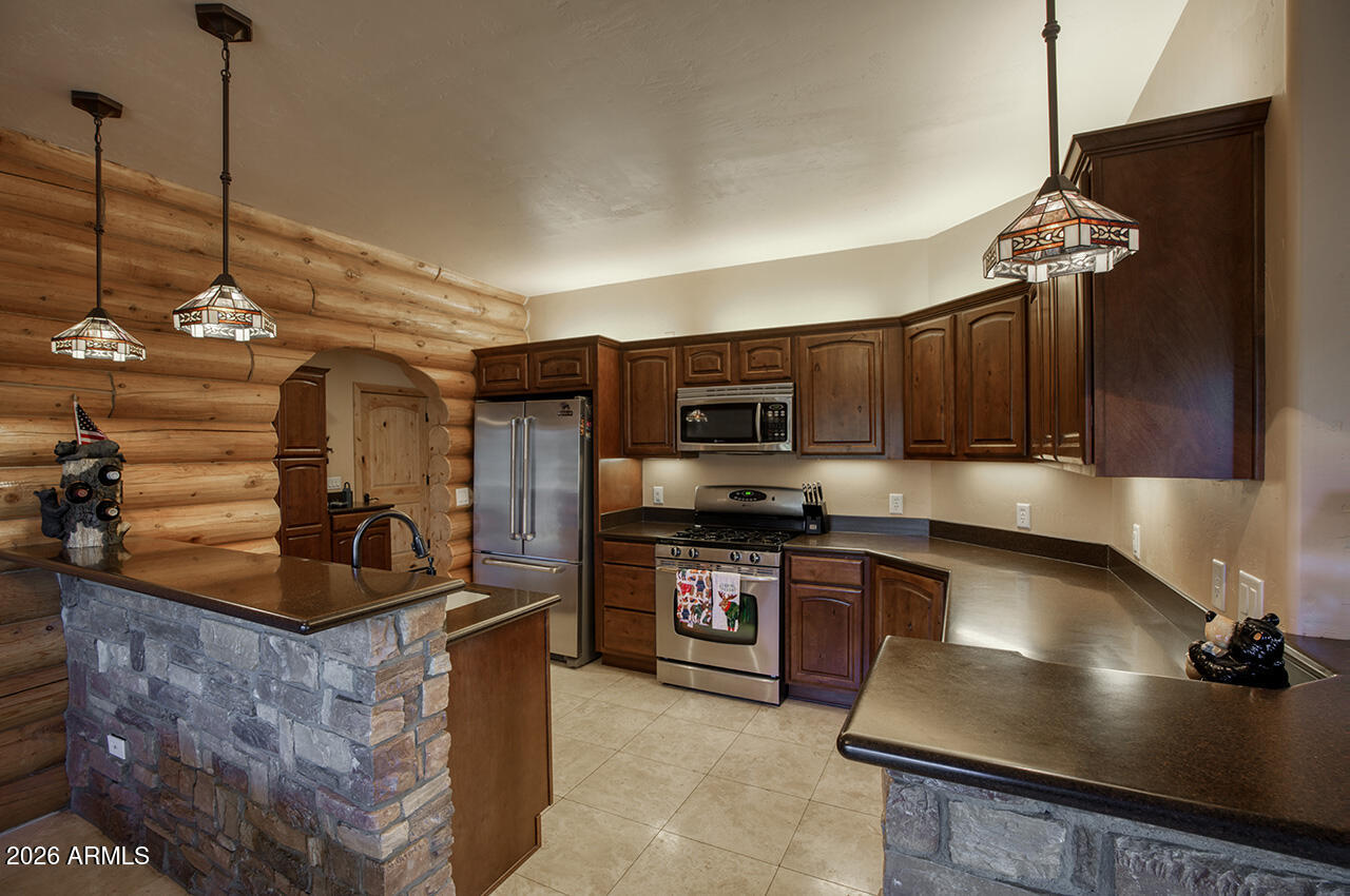 13090 Ghost Train Trail Parks, AZ 86046 - Photo 6 of 23 a kitchen with stainless steel appliances granite countertop a sink a stove and a refrigerator