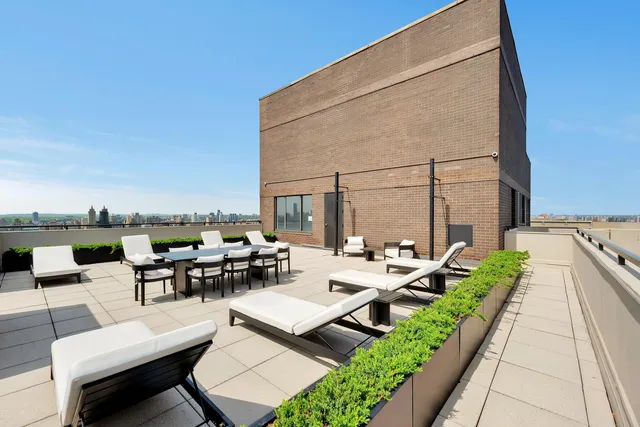 a view of a patio with couches and table and chairs with barbeque grill and couches