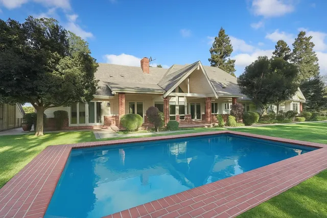 a view of a house with brick walls and a yard