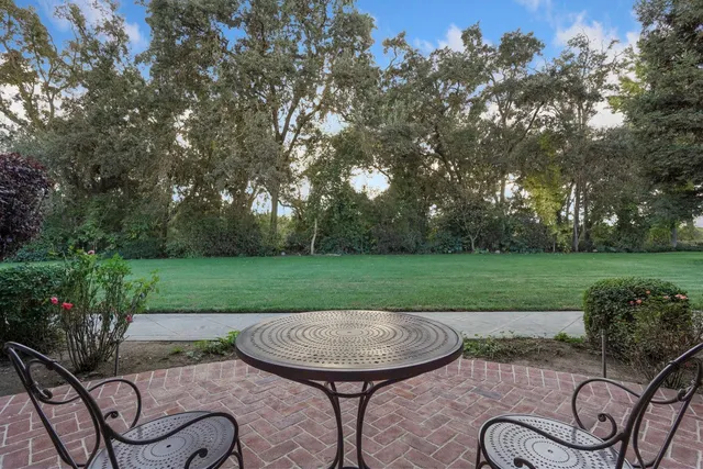a view of an empty room with wooden floor fireplace and a window