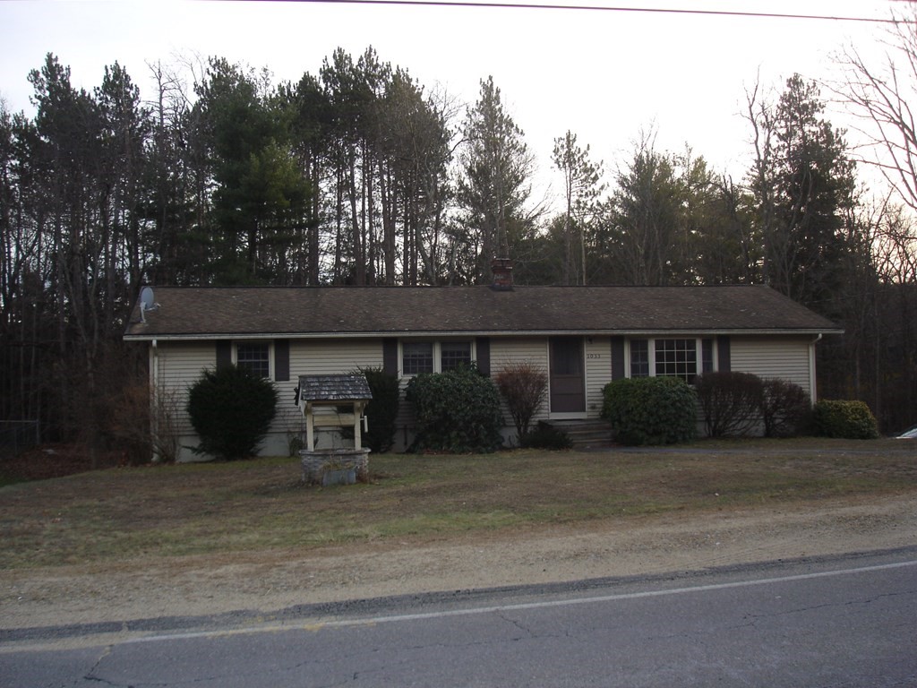a view of a house with a yard and a large tree
