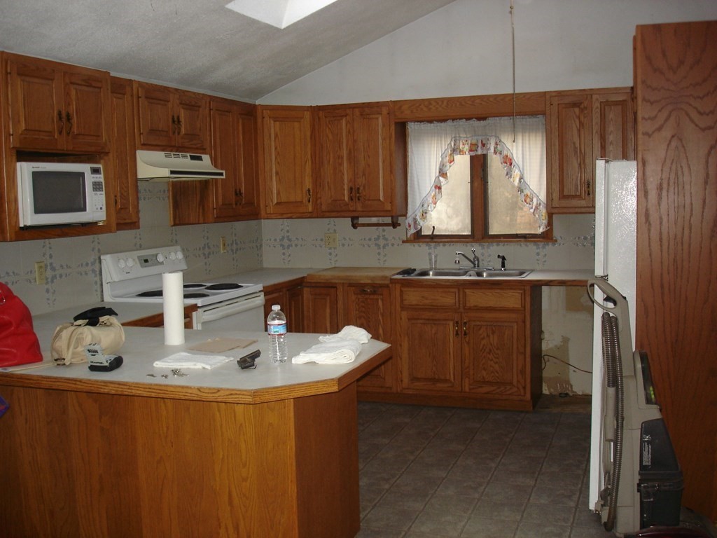 1033 Turnpike Road Ashby, MA 01431 - Photo 2 of 12 a kitchen with kitchen island granite countertop a sink stove and cabinets