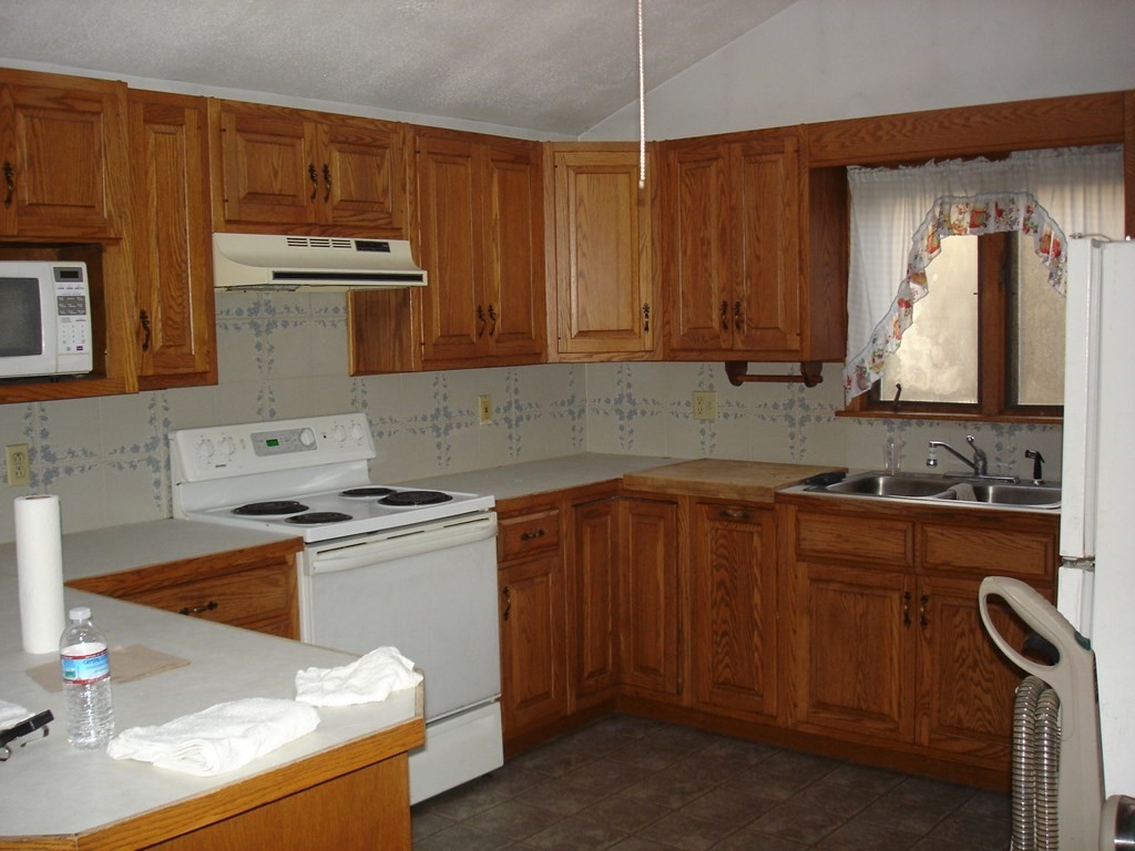 1033 Turnpike Road Ashby, MA 01431 - Photo 3 of 12 a kitchen with stainless steel appliances wooden cabinets and a stove top oven