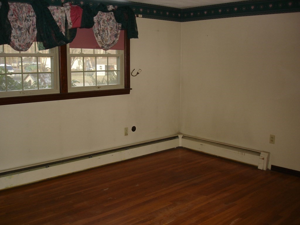 1033 Turnpike Road Ashby, MA 01431 - Photo 5 of 12 a view of an empty room with wooden floor and a window