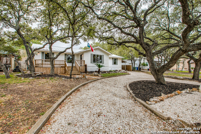 17115 Springhill Drive San Antonio, TX 78232 - Photo 1 of 1 a front view of a house with a yard covered with snow and trees