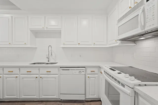 a kitchen with white cabinets and white appliances