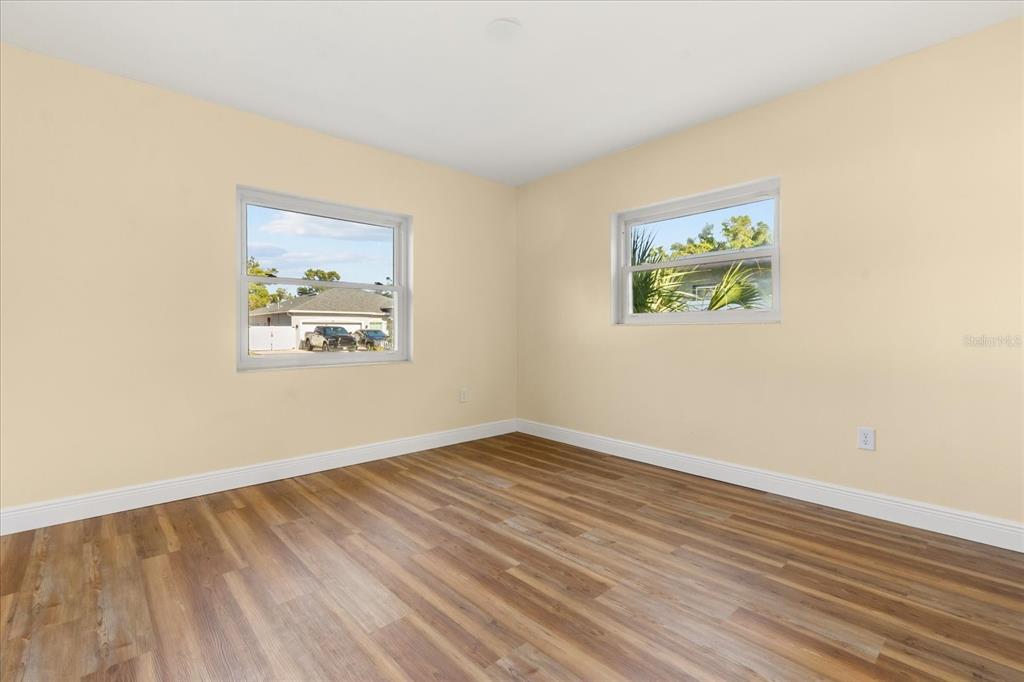 12432 136th Lane Largo, FL 33774 - Photo 12 of 24 an empty room with wooden floor and painting on the wall