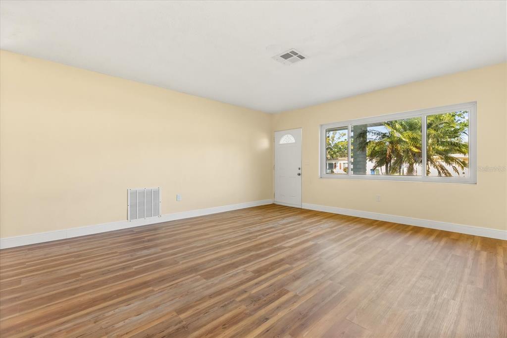 12432 136th Lane Largo, FL 33774 - Photo 6 of 24 a view of an empty room with wooden floor and a window