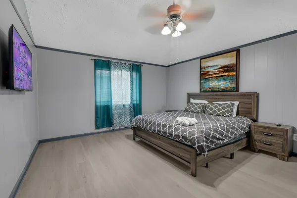 a bedroom with a large bed and a chandelier