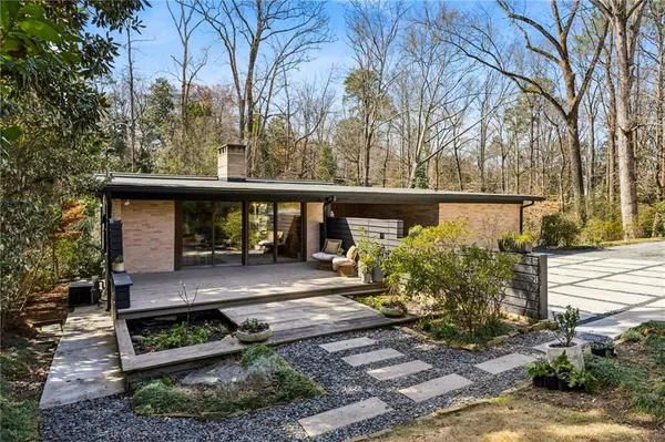 a view of a deck with large trees and a wooden fence