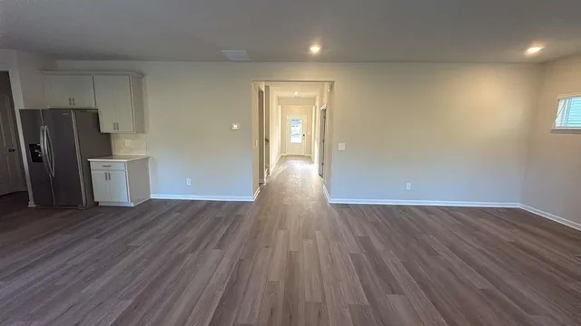 a view of a livingroom with wooden floor and electronic appliances