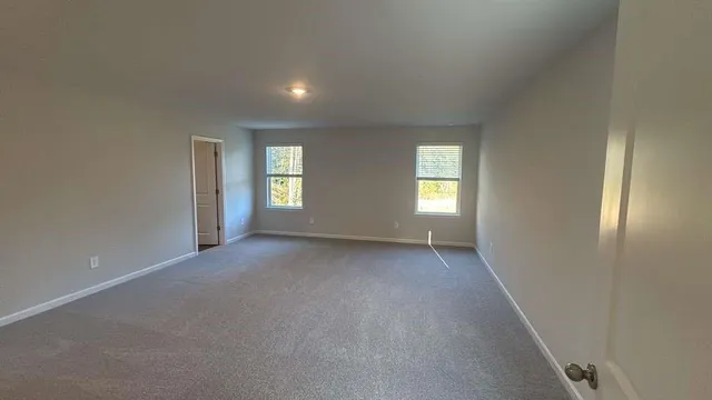 an empty room with windows and closet in a room
