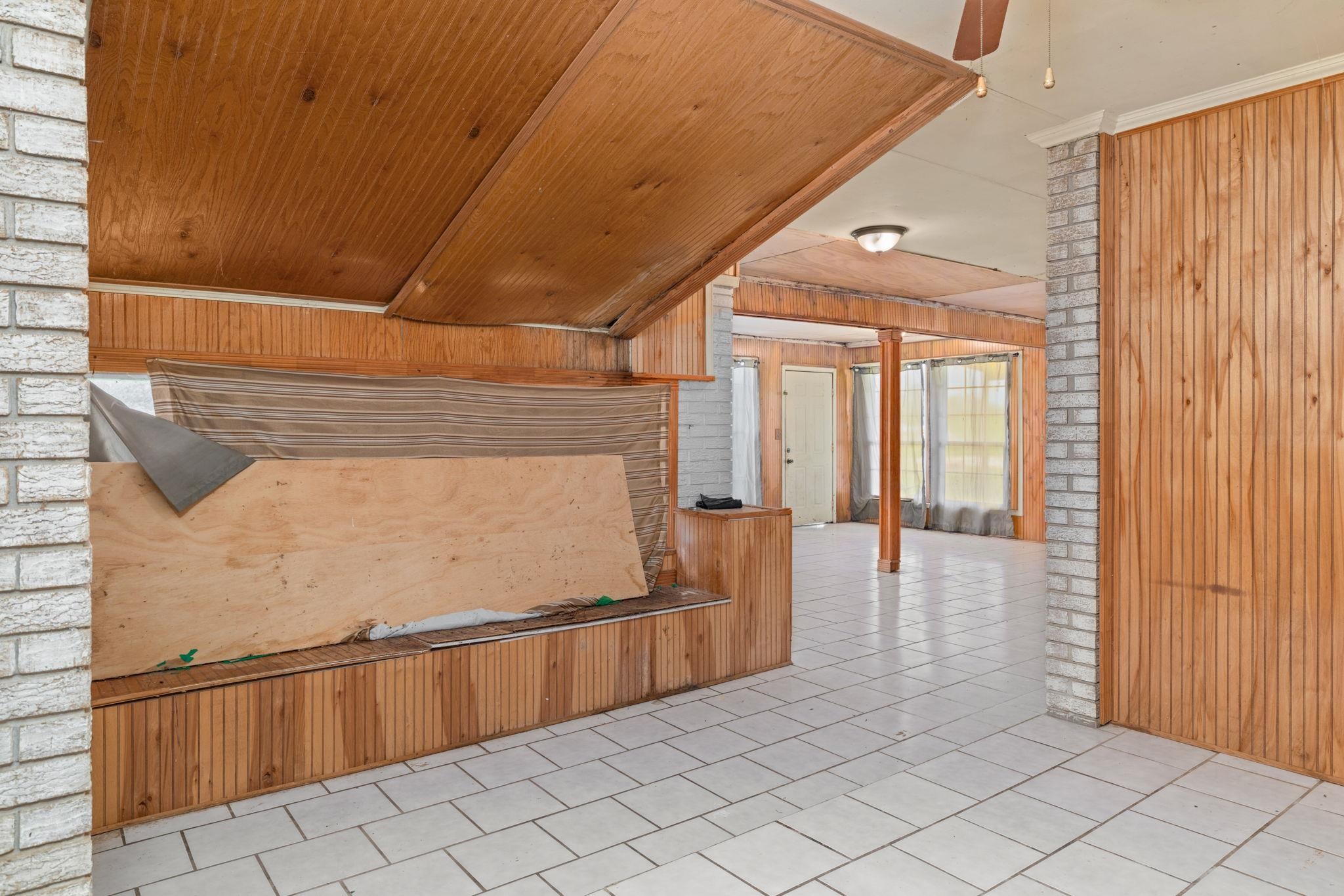 60116 Seminole Road Smithville, MS 38870 - Photo 8 of 38 White brick accents, wood paneling, wood-finish ceiling, and white tile flooring