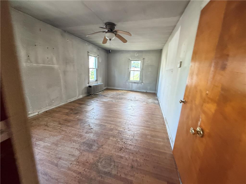 3051 Keystone Street Bethlehem, PA 18020 - Photo 11 of 18 Well-lit room with wood floors and a charming ceiling fan, offering a versatile layout.