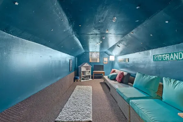 a living room with lots of couch and a potted plant