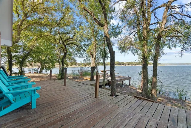 a park with trees and bench next to a yard