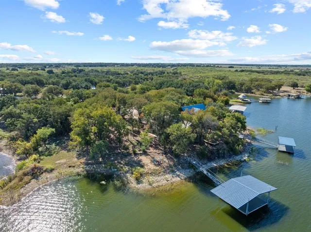 an aerial view of residential houses with outdoor space and lake view