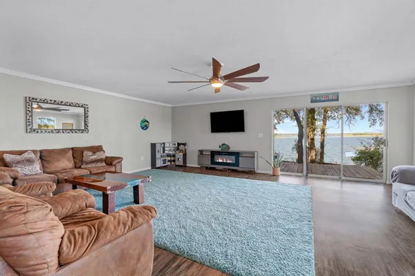 a living room with furniture and a flat screen tv with kitchen view