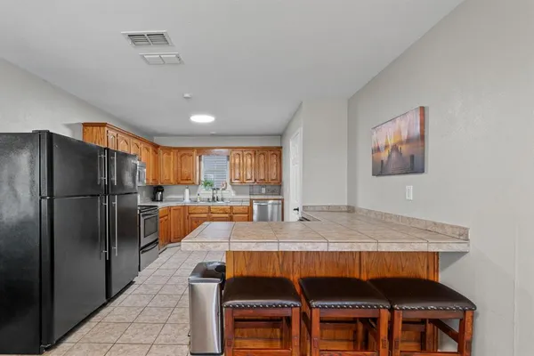 a kitchen with a table chairs refrigerator and cabinets