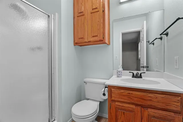 a bathroom with a granite countertop toilet sink and mirror