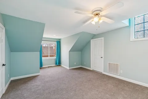 an empty room with fan and windows