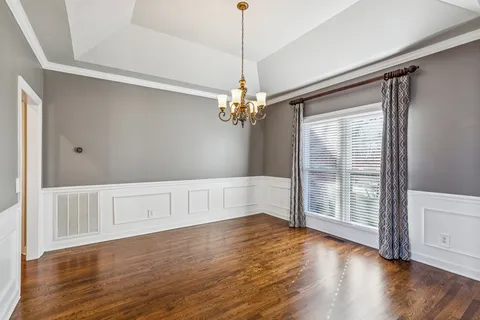 a view of a room with wooden floor and chandelier