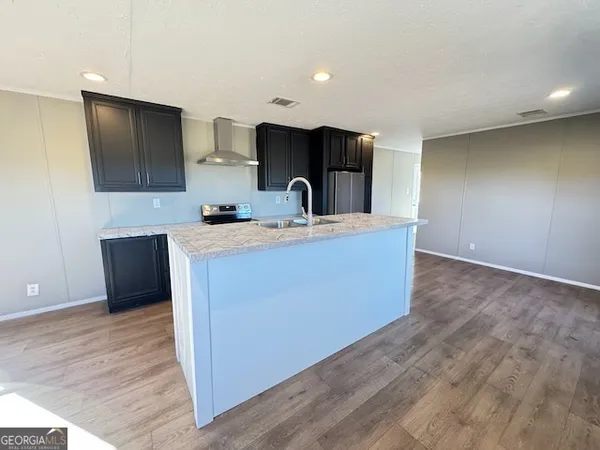 a kitchen with stainless steel appliances granite countertop a sink a stove and a wooden floors